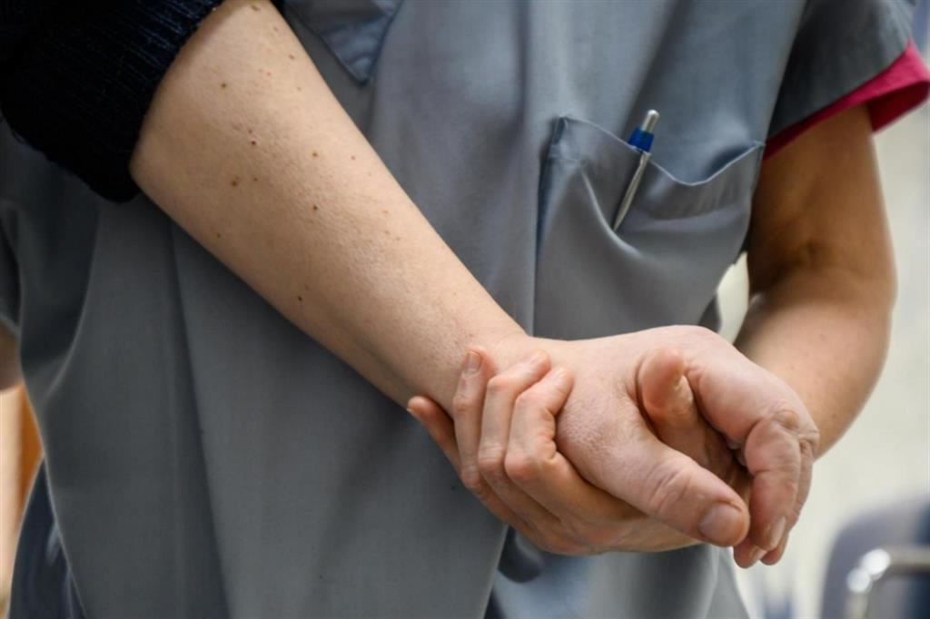 Un'infermiera sostiene una paziente all'hospice del Cottolengo