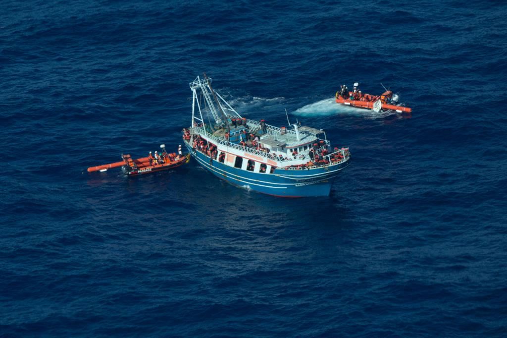 I soccorritori della nave Geo Barents in acqua che avvicinano il motopesca per effettuare il trasbordo delle persone