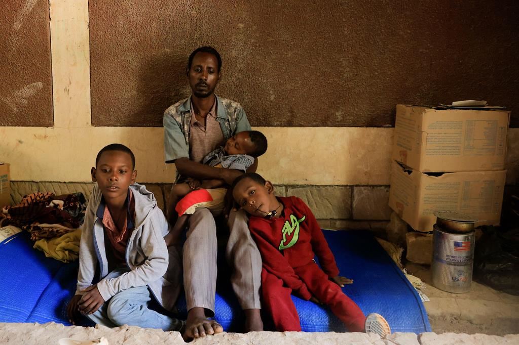 Un uomo in fuga dalle violenze del Tigrai con i figli in un centro dell'Onu ad Abi Adi, in Etiopia