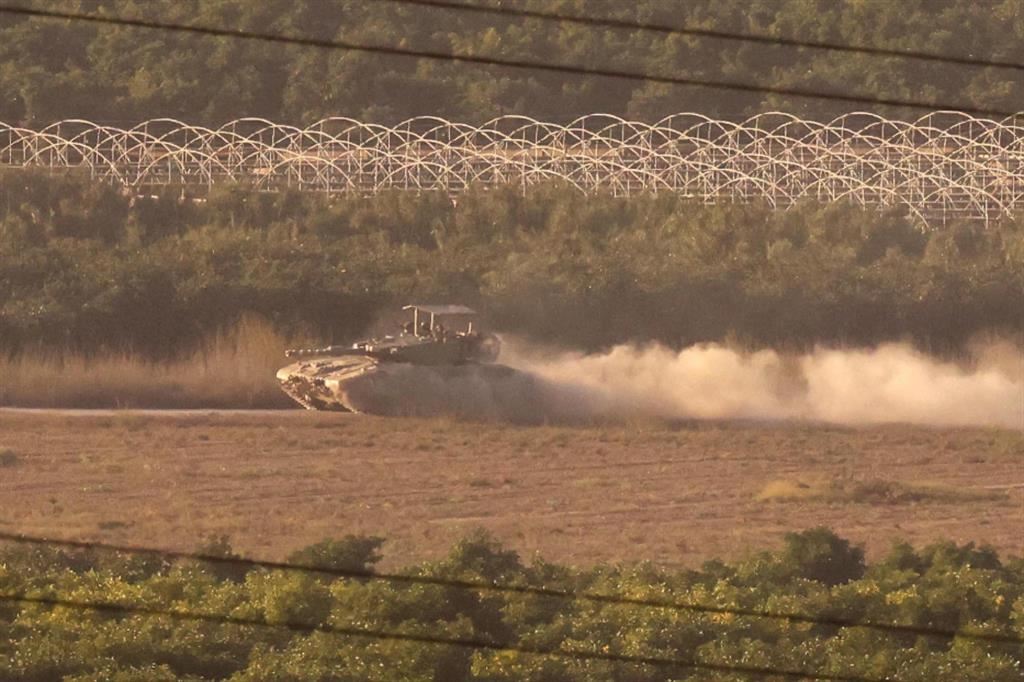 Un carro armato israeliano oltre la barriera di confine con la Striscia di Gaza, fotografato da Sderot in Israele