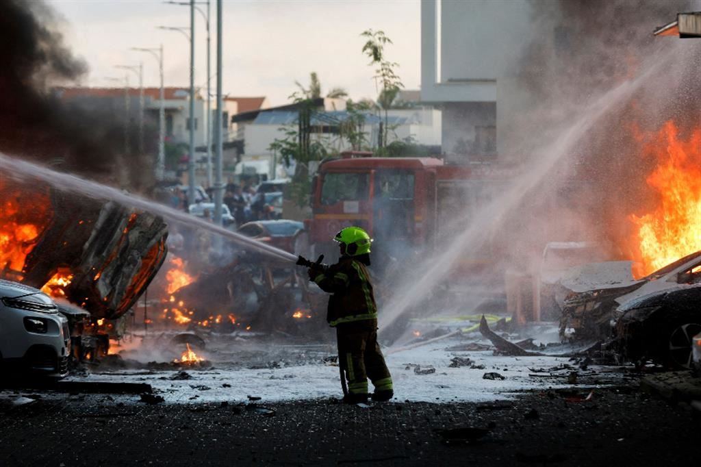 Un vigile del fuoco spegne le fiamme provocate dai razzi caduti sulla città israeliana di Ashkelon