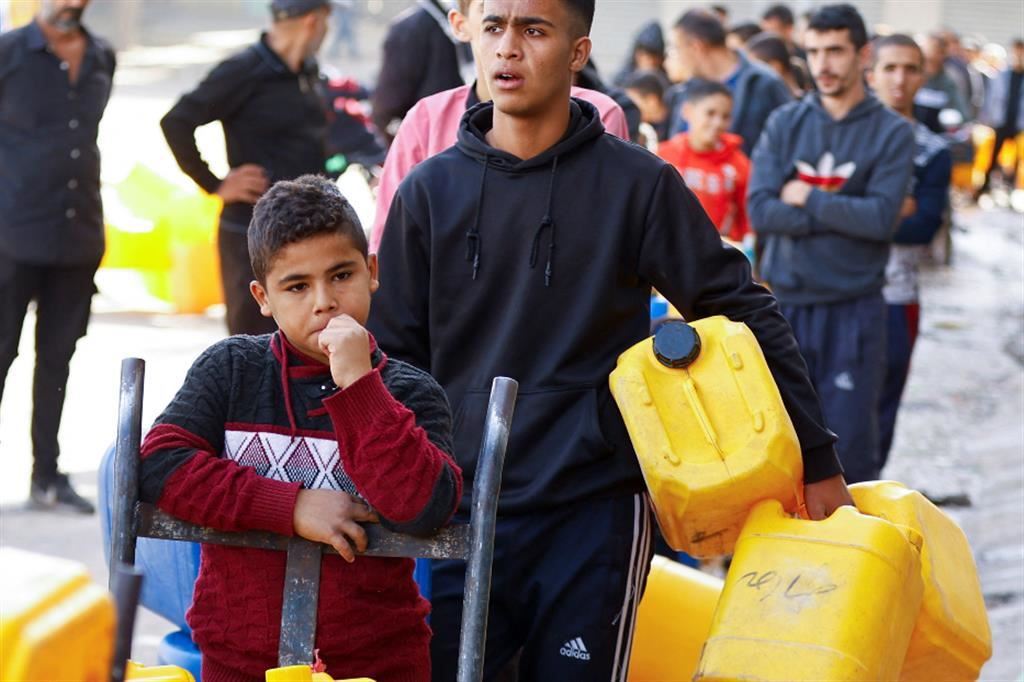 Ragazzi palestinesi in coda per il rifornimento d'acqua a Gaza