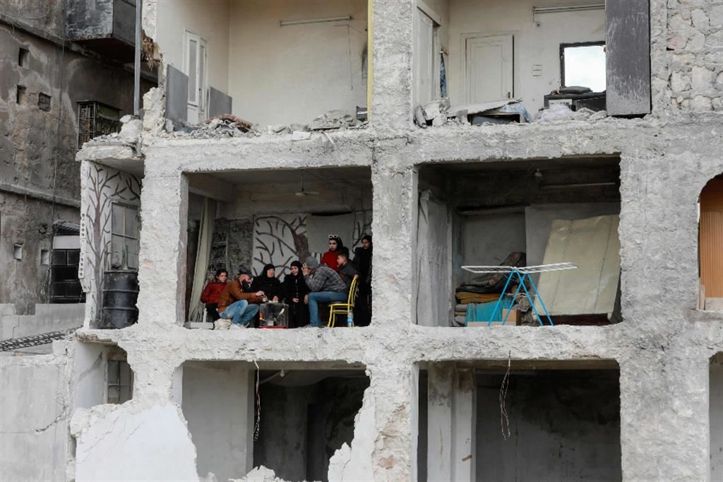 Una famiglia nella casa distrutta di Aleppo