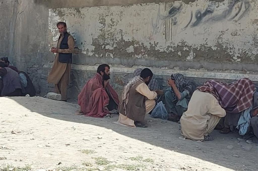 Un gruppo di "schiavi dell'oppio" su una spianata di Kabul