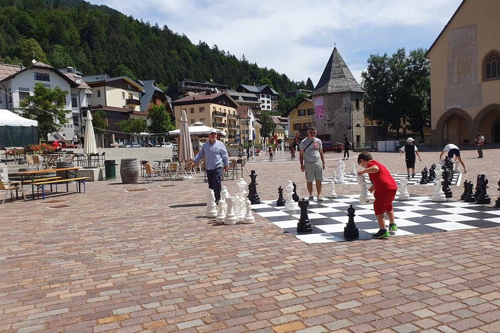 La piazza di Tarvisio con giovani e adulti appassionati di scacchi