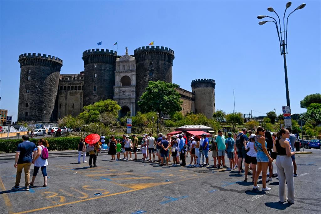 In piazza del Municipio a Napoli i turisti in fila al terminal del bus Citysightseeing attendono il loro turno per la visita