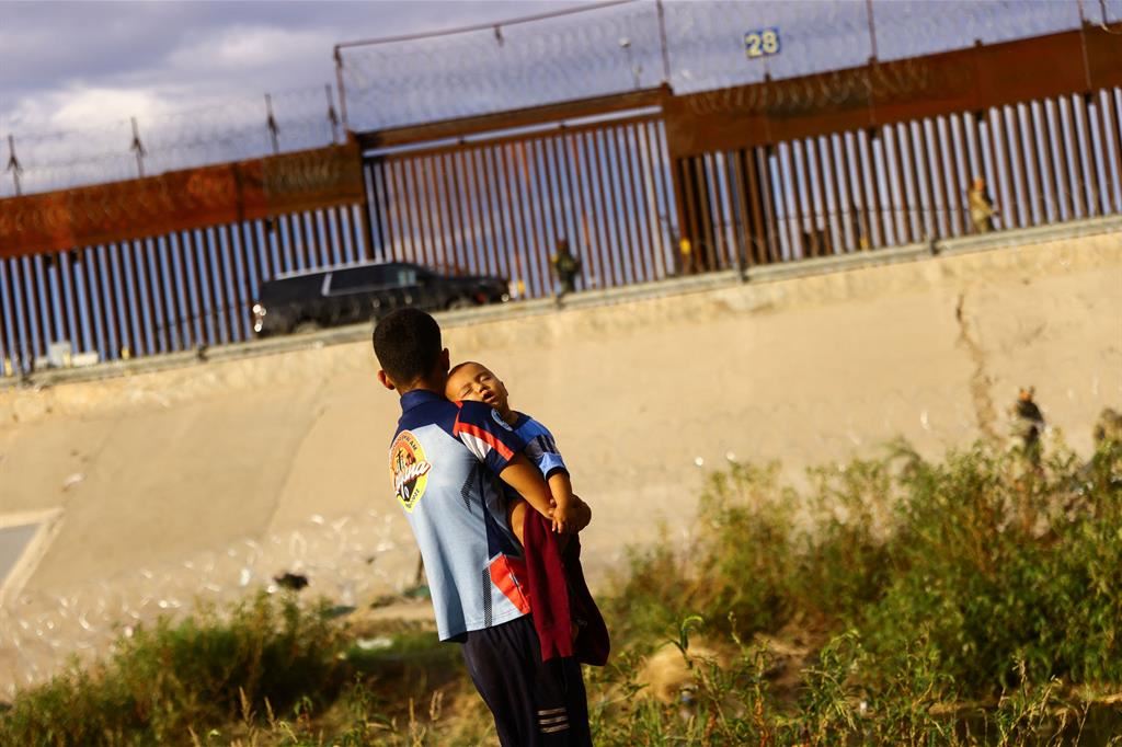 Ragazzo con il, fratellino davanti al muro di Ciudad Juárez, la città al confine con gli stati Unikti nello Stato di Chihuahua di