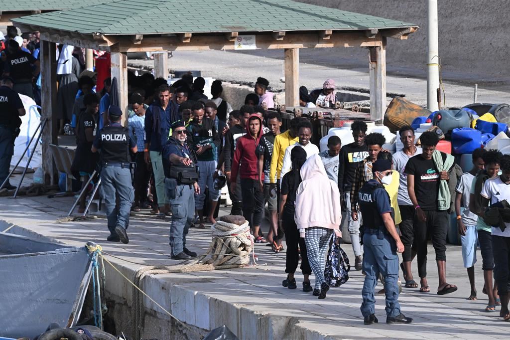 Migranti in partenza su una banchina del porto di Lampedusa