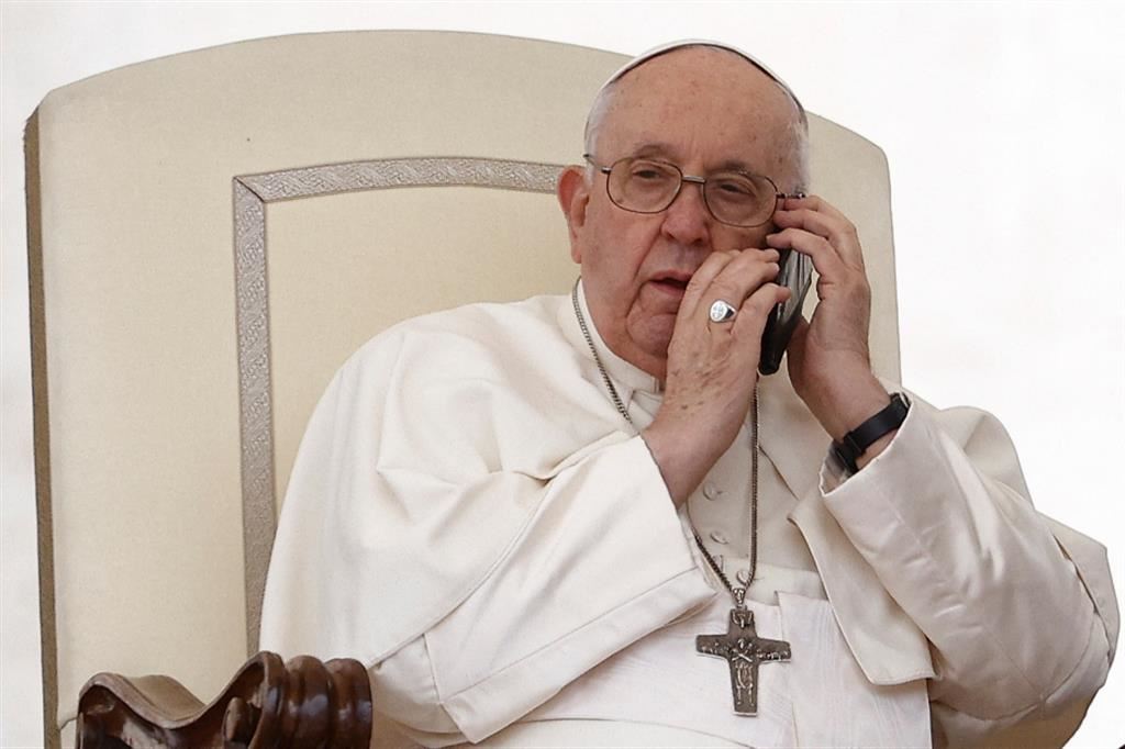 Il Papa ascolta per qualche secondo la telefono durante l'udienza del mercoledì