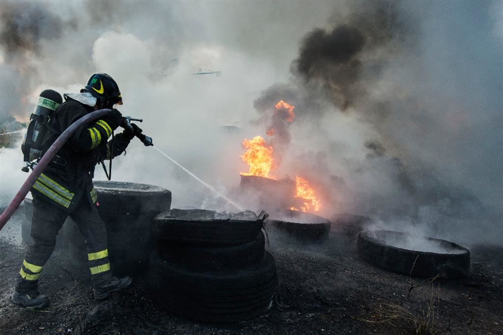Vigili del fuoco in azione per spengere un incendio in una discarica abusiva di rifiuti tossici nella Terra dei fuochi, in Campania