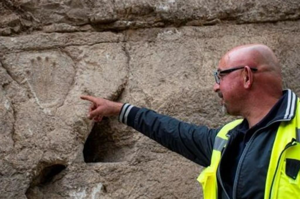 Zubair Adawi, direttore degli scavi della Israel Antiquities Authority, mostra la mano scolptita sul Muro Occidentale