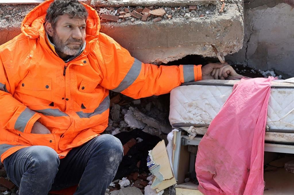 Mesut Hancer tiene la mano della figlia 15enne Irmak, morta nel crollo della sua casa a Kahramanmaras, nella Turchia meridionale