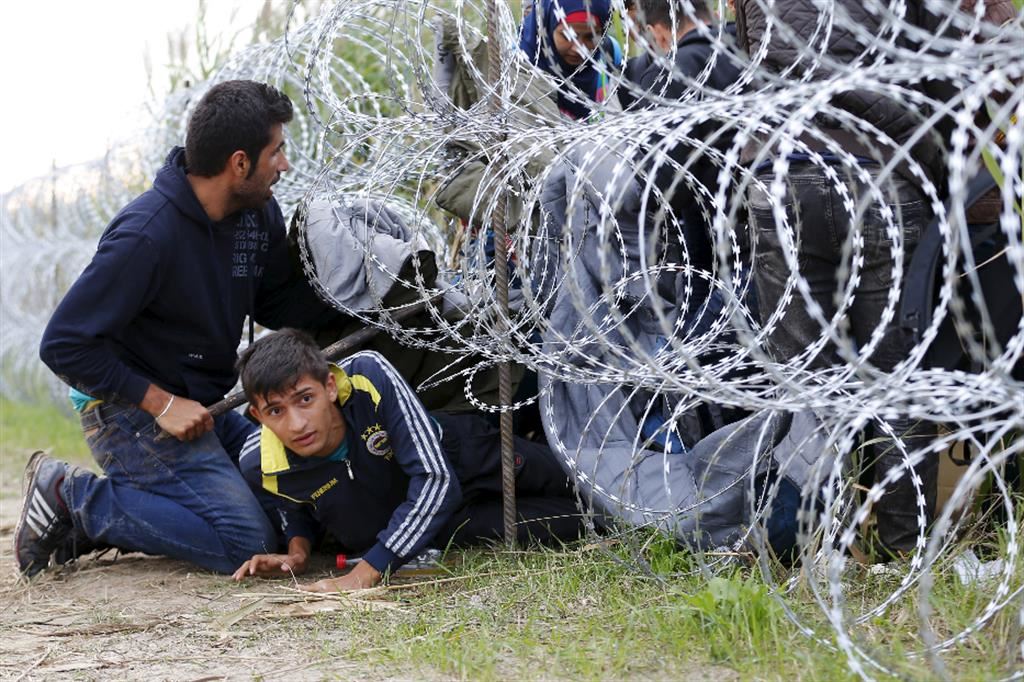 Profughi siriani tentano di passare sotto il muro di filo spinato sistemato lungo il confine tra Ungheria e Serbia, vicino alla città di Roszke. La barriera, costruita dal governo ungherese per respingere i migranti, è lunga 175 chilometri