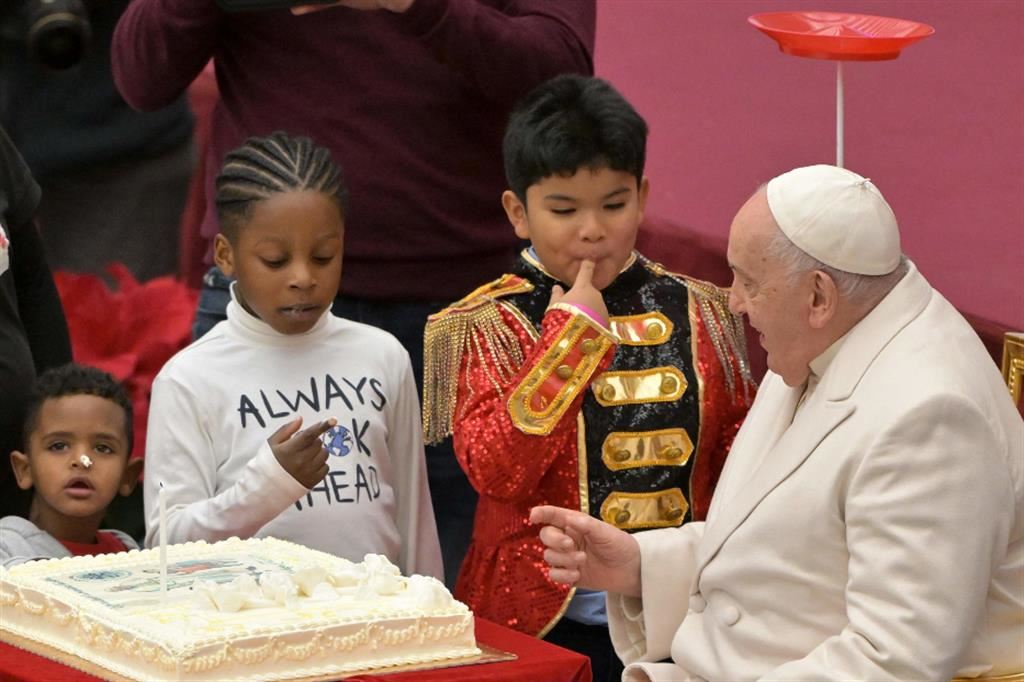 Il Papa tra i bambini che gli portano la torta di compleanno