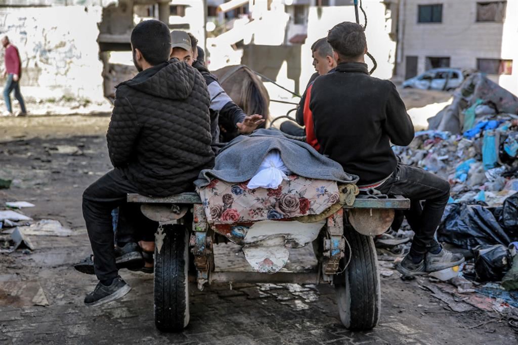 I familiari di un defunto portano via dall'ospedale al-Shifa il cadavere in un sacco bianco: l'immagine è stata scattata il 15 marzo scorso