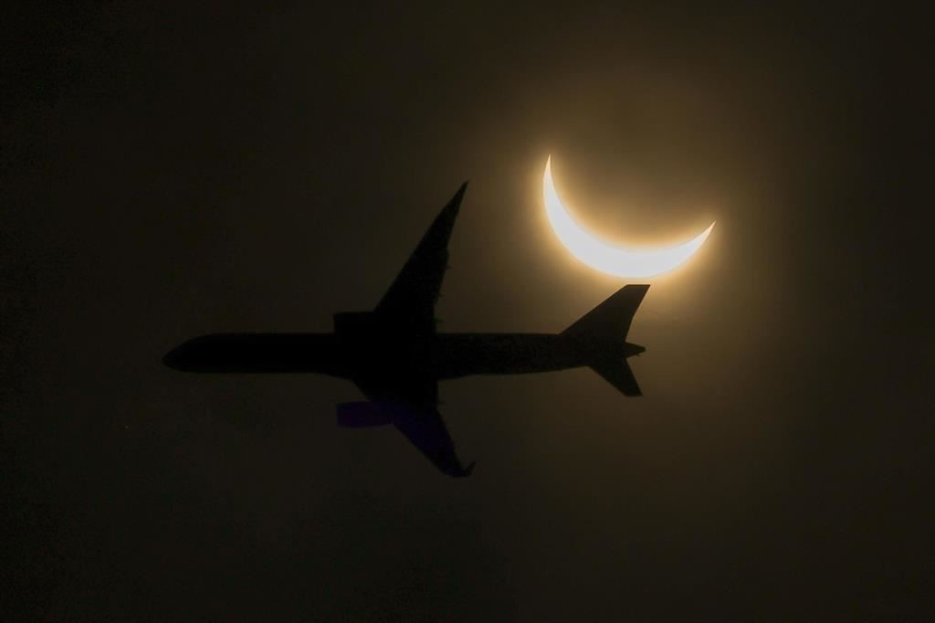 La coda di un aereo si staglia sull'eclissi - Ansa