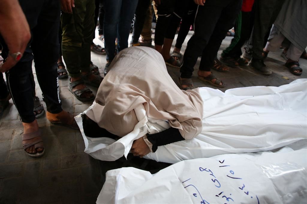 Una donna piange sulla salma di un defunto all'ospedale Abu Yusef al-Najjar di Rafah