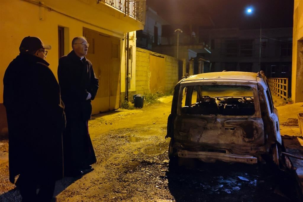 Il sacerdote e il vescovo a Varapodio, alcuni giorni fa, di fianco alla carcassa dell'auto