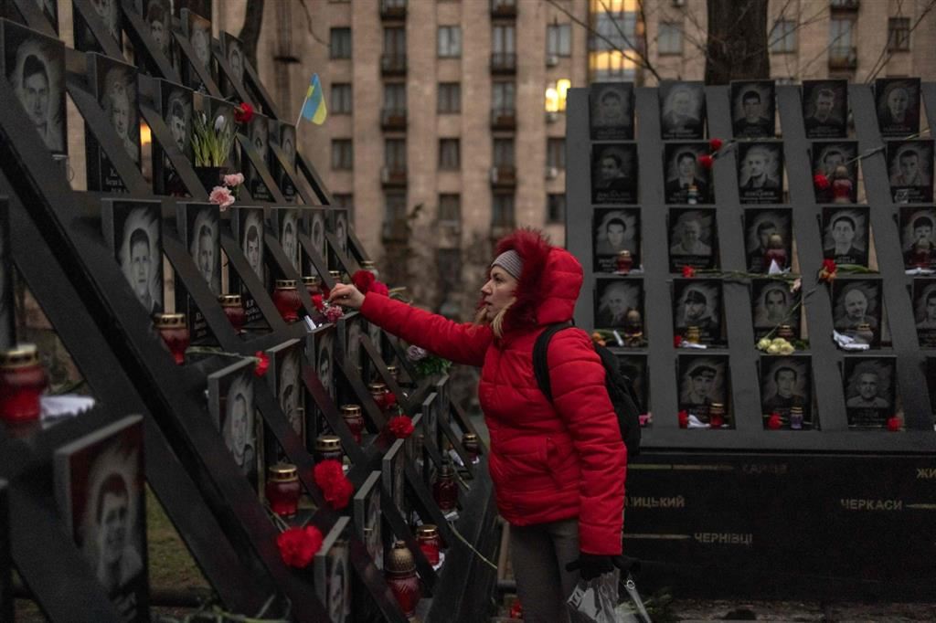 Una donna porta fiori al memoriale dei caduti di piazza Maida, a Kiev