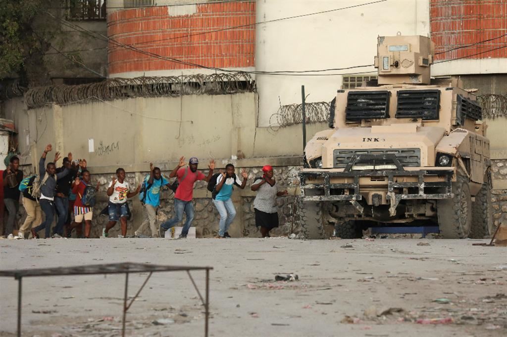 Scene di vita quotidiana a Port-au-Prince con le mani alzate per non essere scambiati dalla polizia per membri delle gang